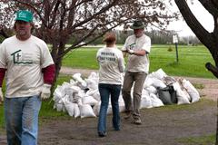 Volunteers performing flood cleanup by moving sandbags in Oakport, Minnesota