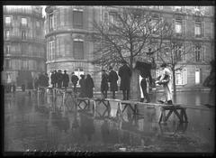 People walking on raised wooden planks during the 1910 floods on Avenue Montaigne in Paris' 8th arrondissement