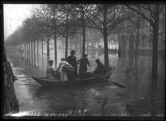 People in a boat navigating flooded Avenue Montaigne during the 1910 Paris floods in the 8th arrondissement