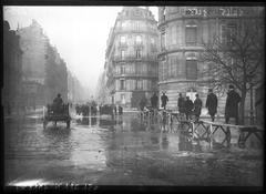 Flooded Avenue Montaigne in Paris during 1910 flood with people using carts and planks on stilts to pass
