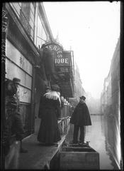Man on a ladder placed on planks above floodwaters on Rue Saint-Dominique, Paris during 1910 flood