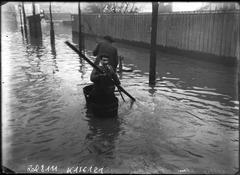 Black and white photo of people using buckets as boats during the 1910 floods on Avenue Félix Faure in Paris 15th arrondissement