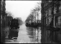 Flooded Avenue Félix Faure in Paris 15th arrondissement with boats and horse-drawn carriages in January 1910