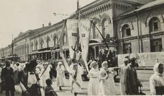 Women carrying a religious banner on Liteyny Prospect in Petrograd with boats along the Neva River and people in the background