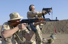 Range Officer firing a Heckler and Koch MP5K submachine gun and teaching Special Agent Denny Wood to fire AKM assault rifle at Baghdad International Airport range during Operation Iraqi Freedom