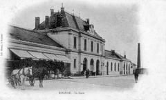 Historic train station building with horse-drawn carriages in front