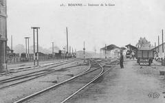 View of train tracks and distant covered platforms with passenger building at Roanne station