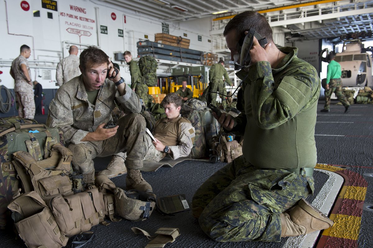 Two soldiers from Royal New Zealand Army and Canadian Light Infantry testing portable radios aboard USS Peleliu during RIMPAC 2014