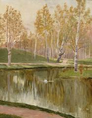 Kaisaniemen lammikko pond in Helsinki surrounded by trees and water plants under blue sky