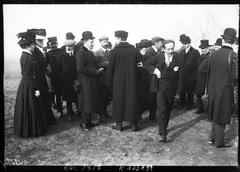 Early aviation pioneers including Thérèse Peltier, Ferdinand Ferber, Henry Deutsch, Léon Delagrange, Henry Farman, Louis Blériot, Ernest Archdeacon, and Alberto Santos-Dumont at Issy-les-Moulineaux in October 1907