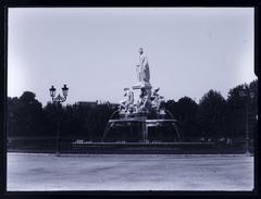 Pradier Fountain sculpture in a public garden in Nîmes, France with trees and street lamp
