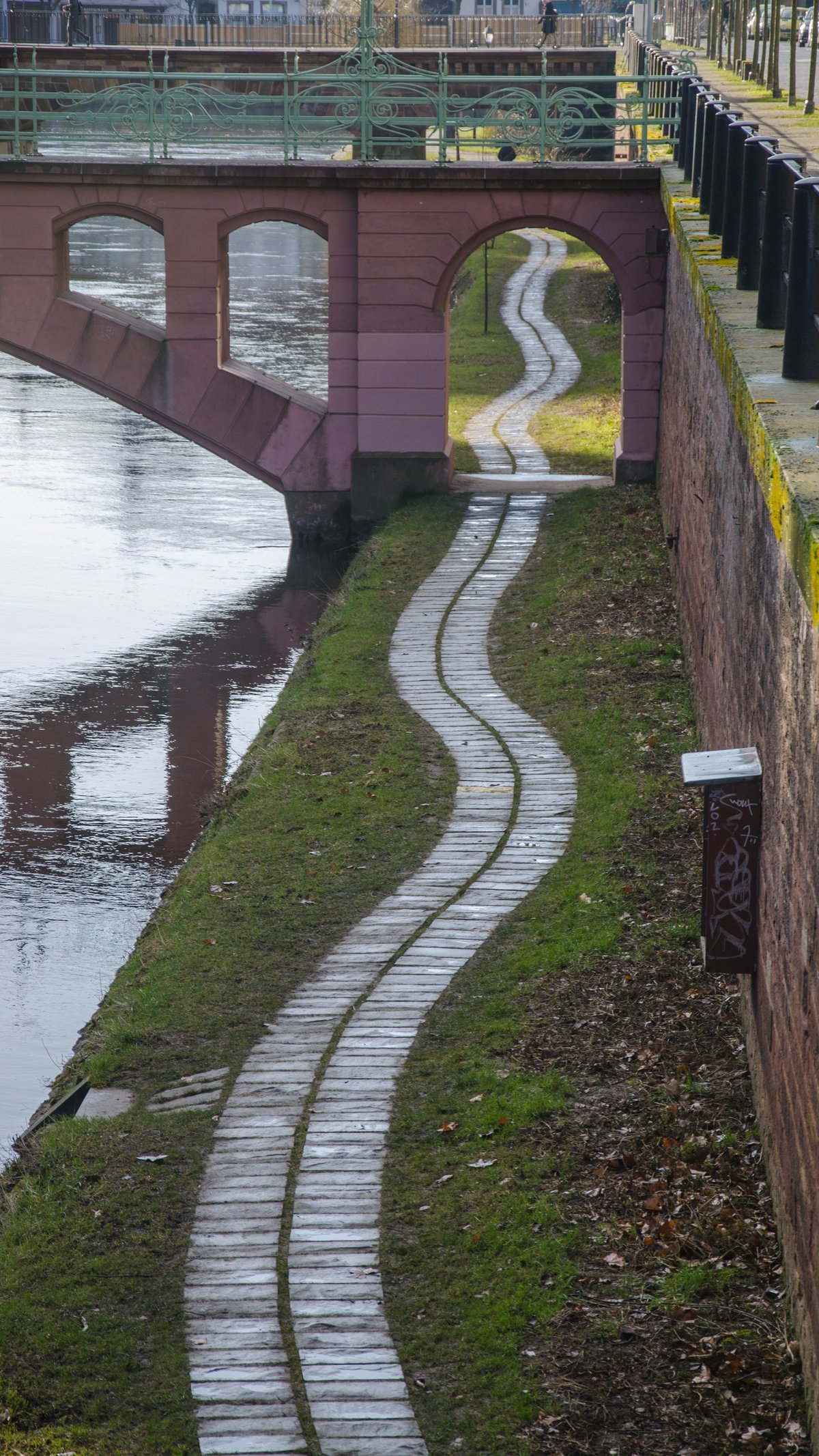 Winding towpath along a calm river in Strasbourg during summer