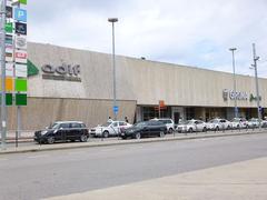 Girona train station building with tracks and overhead wires under cloudy sky