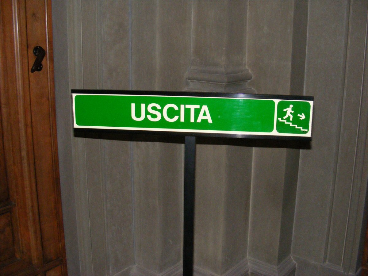 Green exit sign with arrow and stairs symbol at Palazzo Pitti in Florence