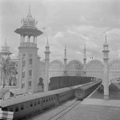Historic black and white photo of Kuala Lumpur railway station building in 1946 with train arriving