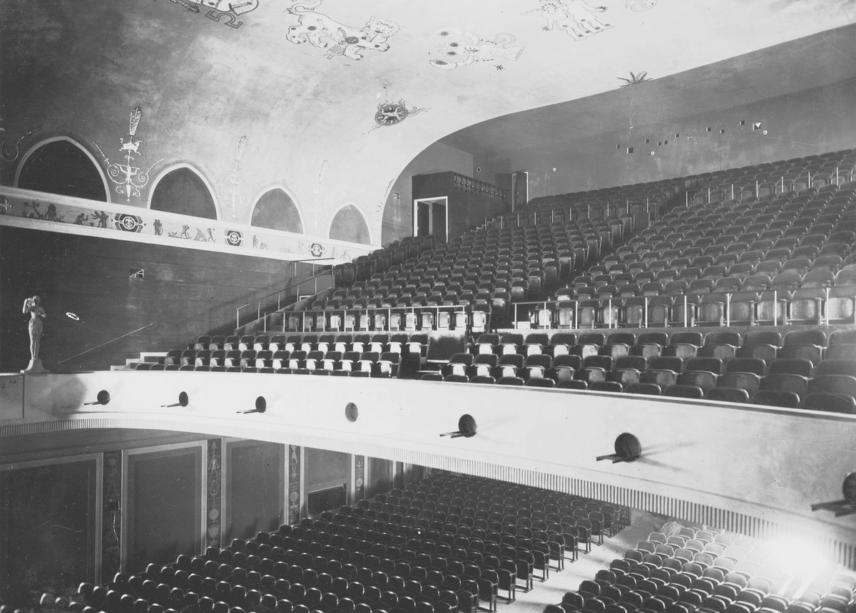 Interior view of Göta Lejon theater saloon with rows of red seats and ornate architectural details
