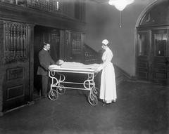 Nurse and orderly transporting child on stretcher to operating room at Hospital for Sick Children circa 1915