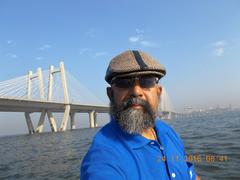 Seafarer Rudolph A. Furtado taking a selfie on a fishing canoe with Bandra-Worli sea link in the background