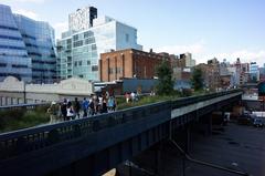 Visitors walking on the first section of High Line Park over 18th Street with Frank Gehry's IAC building in the background