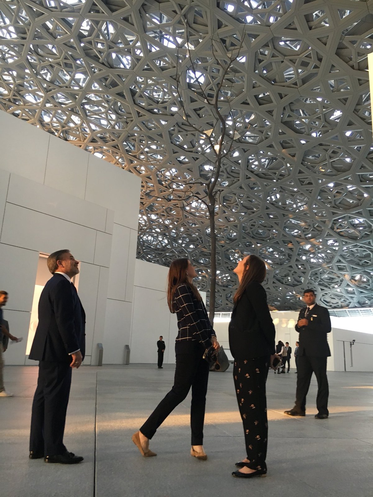 Interior view of the Louvre Abu Dhabi museum with intricate ceiling and visitors
