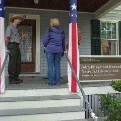 Ranger welcoming visitor on front porch of JFK's birthplace