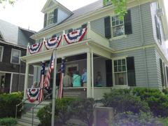 Tour group waiting on the porch of JFK's birthplace decorated with red white and blue banners