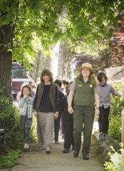 Teacher and park ranger leading third grade students down tree lined street towards John F Kennedy birthplace on ceremony day