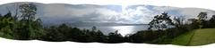 Panoramic view of Arenal Volcano in Costa Rica with lush green landscape and partly cloudy sky