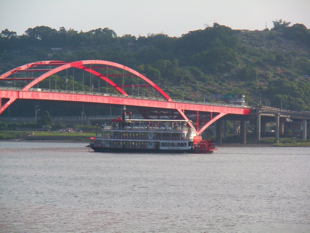 Great River Queen cruise ship sailing under Guandu Bridge in Taipei