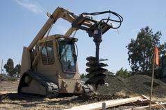 Sgt. Andre Burnett operating skid-steer digging holes at Isaac Lawson Memorial site in Fairfield, California
