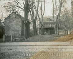 Exterior view of historic house at 5140 Main St. with bare trees and studio in rear