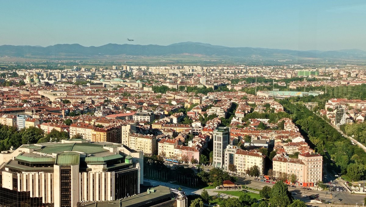 Plane approaching Sofia airport for landing over city landscape