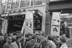 Black and white photo of a demonstration featuring comic strip characters in Kalverstraat, Amsterdam on April 17, 1971
