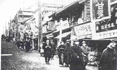 Street view of Kagurazaka in 1908 showing traditional Japanese buildings and people walking