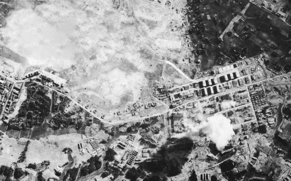 Aerial view of the Tachikawa Aircraft Company in Japan under attack by U.S. Navy carrier aircraft in February 1945 during World War II