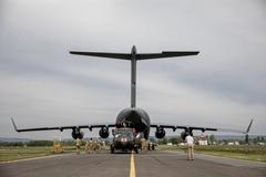 U.S. Soldiers and Air Force personnel loading HH-60 Medevac Black Hawk helicopter onto C-17 aircraft for Swift Response 2022 exercise
