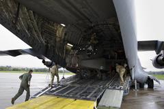 Soldiers from 1st Battalion, 3rd Aviation Regiment, 12th Combat Aviation Brigade loading AH-64D Longbow helicopters onto a C-17 aircraft at Wiesbaden Army Airfield