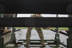 Soldiers of 12th Combat Aviation Brigade loading AH-64D Longbow helicopters onto a C-17 transport aircraft at Wiesbaden Army Airfield