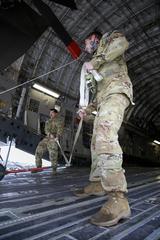 Soldiers from 1st Battalion, 3rd Aviation Regiment load AH-64D Longbow helicopters onto a C-17 aircraft at Wiesbaden Army Airfield