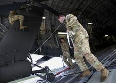 Soldiers of 12th Combat Aviation Brigade preparing to load AH-64D Longbow helicopters onto a C-17 transport aircraft at Wiesbaden Army Airfield, Germany