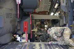 Soldiers from 1st Battalion, 3rd Aviation Regiment loading AH-64D Longbow helicopters onto a C-17 transport aircraft at Wiesbaden Army Airfield