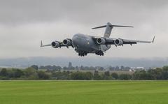 U.S. Air Force C-17 transport aircraft landing at Wiesbaden Army Airfield with soldiers of 12th Combat Aviation Brigade loading AH-64D Longbow helicopters