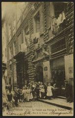 Group of residents and children posing in front of the Maison aux pointes de Diamants on Rue de la Prison in old Marseille, with the storefront of a confectionery visible