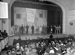 Gratien Gélinas and comedians performing on stage during Fridolinons journals with musicians in orchestra pit at National Monument