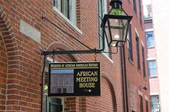 Exterior view of the African Meeting House with a wooden signpost showing Museum of African American History and African Meeting House