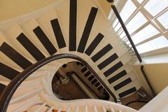 Curved white wooden staircase with black anti-slip strips resembling piano keys at the African Meeting House