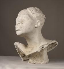 Sculpture of a head with raised gaze, curly hair, flat nose, and full lips