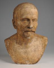 Bust portrait of a man with elongated face, prominent forehead, flat hair, mustache, and goatee