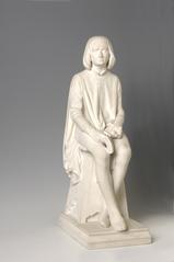 Sculpture of young Dante sitting on a pyramid-shaped stool with trilobed and vegetal motifs, holding a book and looking upwards