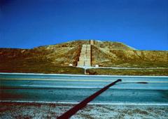Steps ascending a large Cahokia mound visible over a road railing at Cahokia Mounds Historical Site in Illinois
